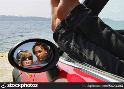 Couple sat in car at the beach