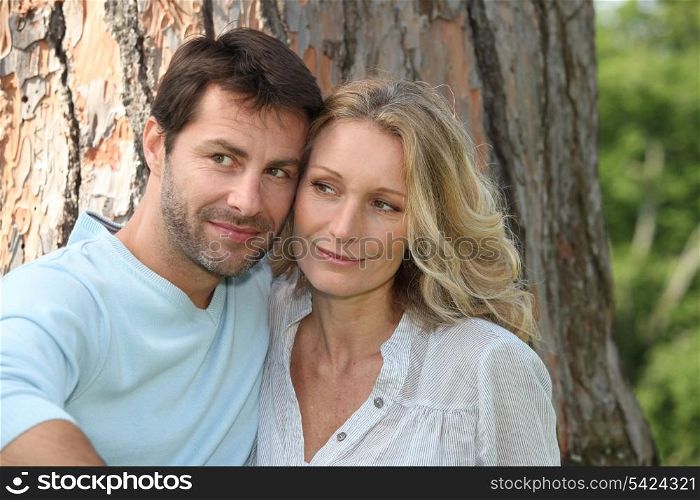 Couple sat in front of tree