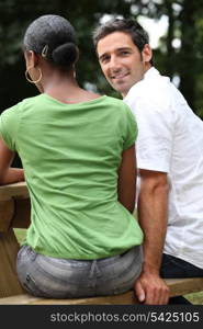 Couple sat on a park bench together