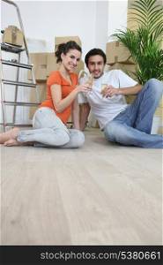 Couple sat on flooring toasting