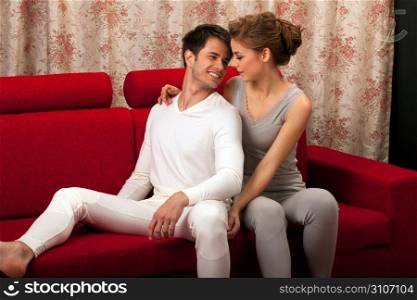 Couple sat on red sofa