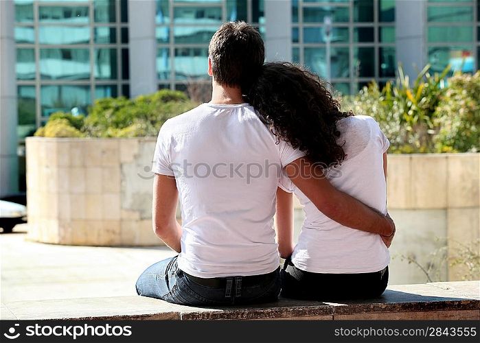 Couple sat outside modern building