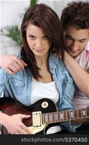 Couple sat with electric guitar