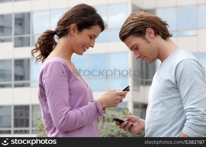 Couple sending text messages outside