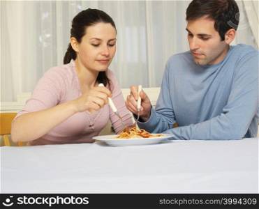 Couple sharing spaghetti bolognese