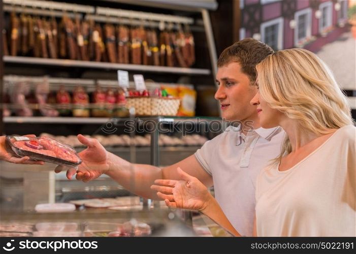 Couple shopping at the supermarket buying meat