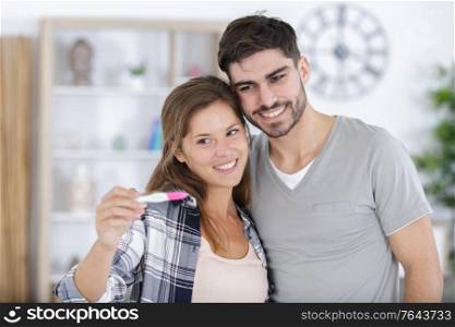 couple showing positive results of pregnancy test