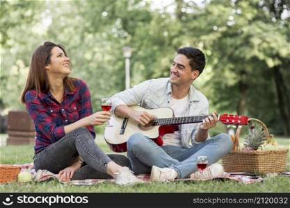 couple singing playing guitar park