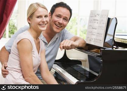 Couple sitting at piano smiling