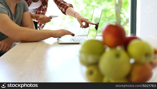 Couple sitting at table making online purchase using credit card