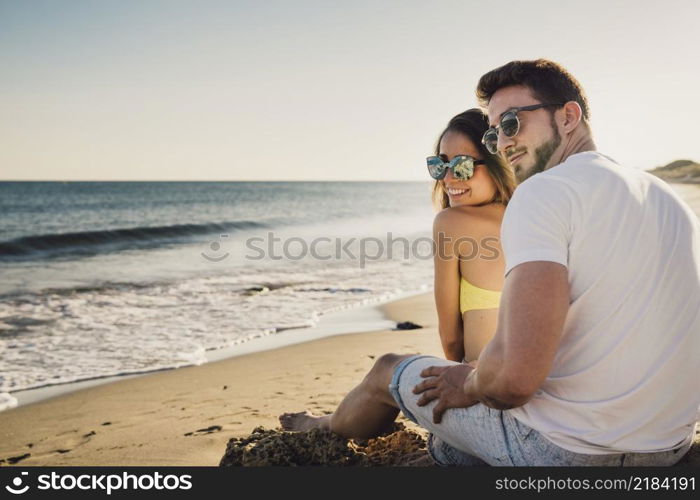 couple sitting by shoreline