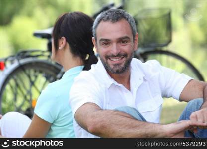 Couple sitting by their bikes in the countryside