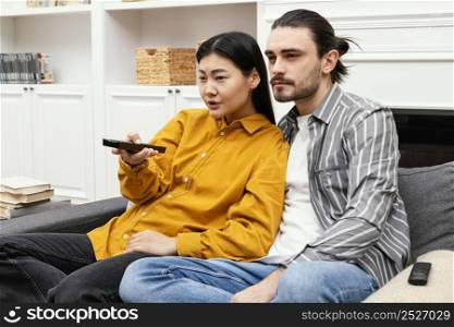 couple sitting couch watching tv being together