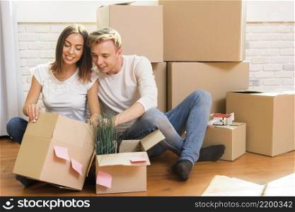 couple sitting floor inspect box
