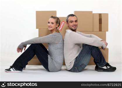 Couple sitting in front of cardboard boxes