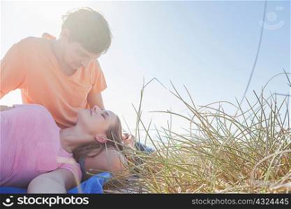 Couple sitting in grass, woman&acute;s head on man&acute;s lap