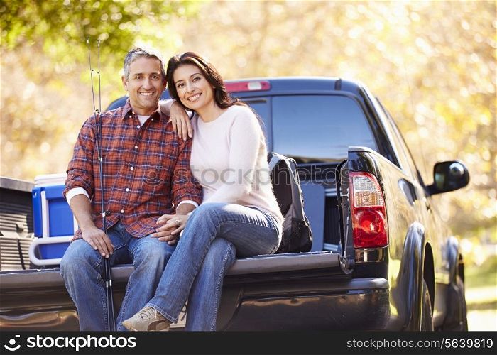 Couple Sitting In Pick Up Truck On Camping Holiday