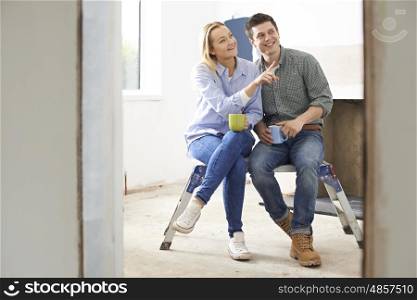Couple Sitting In Property Being Rennovated
