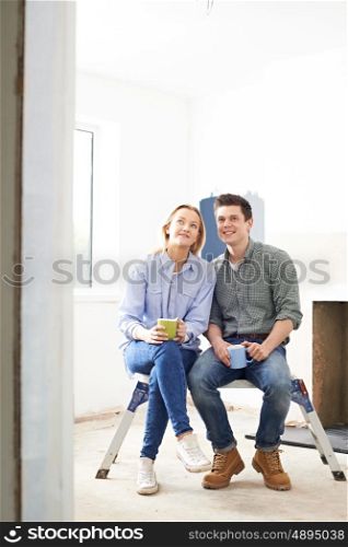 Couple Sitting In Property Being Rennovated