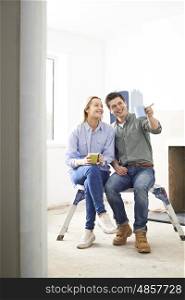 Couple Sitting In Property Being Renovated