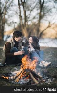 couple sitting near campfire