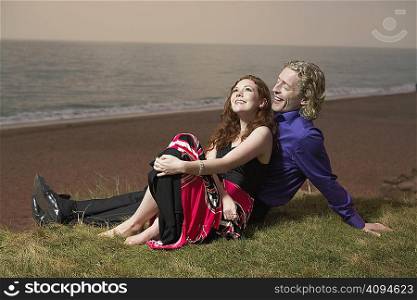 Couple sitting next to a beach