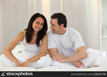 Couple sitting on a bed