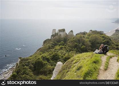 Couple Sitting on an Outlook Above the Water