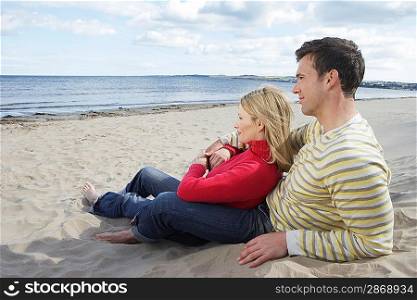 Couple sitting on beach embracing
