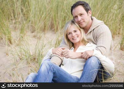 Couple sitting on beach smiling