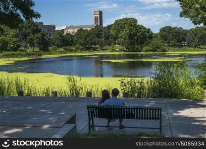 Couple sitting on bench by lake in park, Minneapolis, Hennepin County, Minnesota, USA