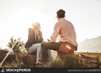 Couple sitting on rocks in field