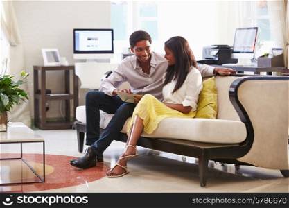 Couple Sitting On Sofa In Hotel Lobby