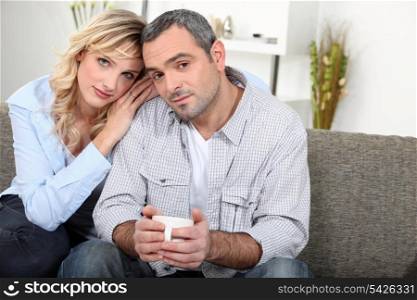 Couple sitting on sofa with a cup of coffee