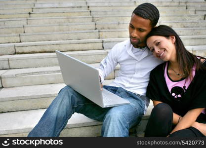Couple sitting on some steps with a laptop