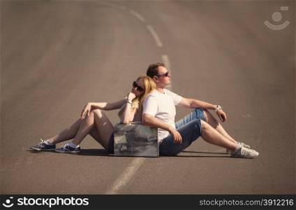 Couple sitting on the road in summer evening, travel concept