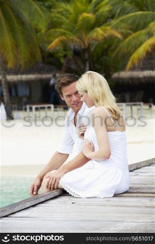 Couple Sitting On Wooden Jetty