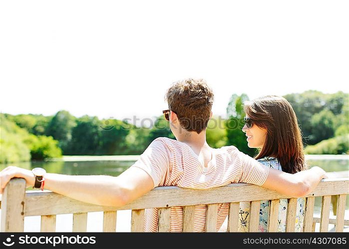 Couple sitting on wooden park bench