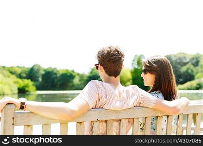 Couple sitting on wooden park bench