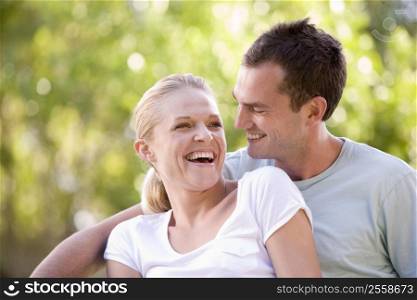 Couple sitting outdoors laughing