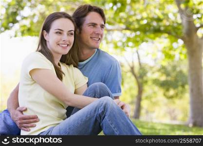 Couple sitting outdoors smiling