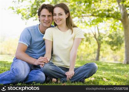 Couple sitting outdoors smiling