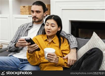 couple sitting sofa watching tv