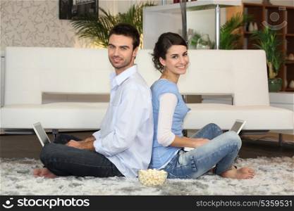 Couple sitting with laptop computers