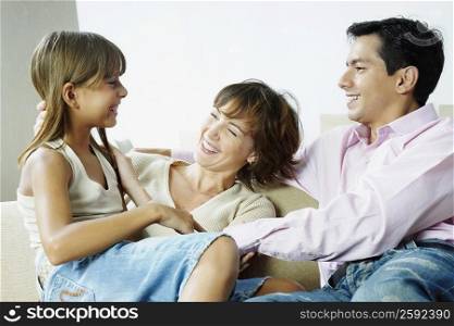 Couple sitting with their daughter and smiling