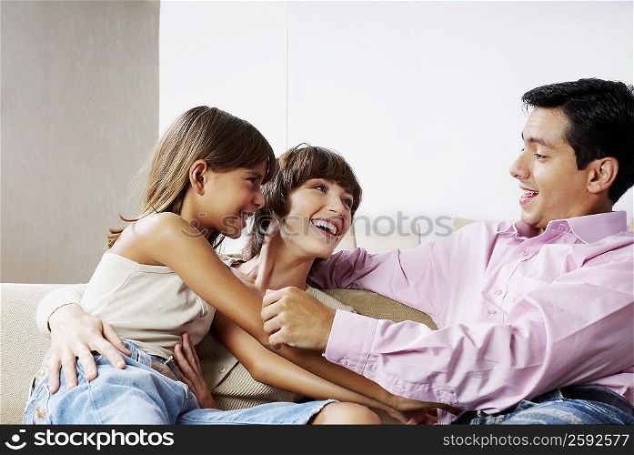 Couple sitting with their daughter and smiling