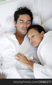 Couple sleeping in bathrobes