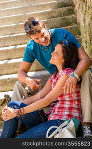 Couple smiling at each other on stairs happy looking sitting