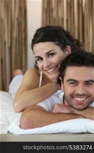 Couple smiling on a bed