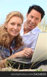 Couple smiling on laptop.